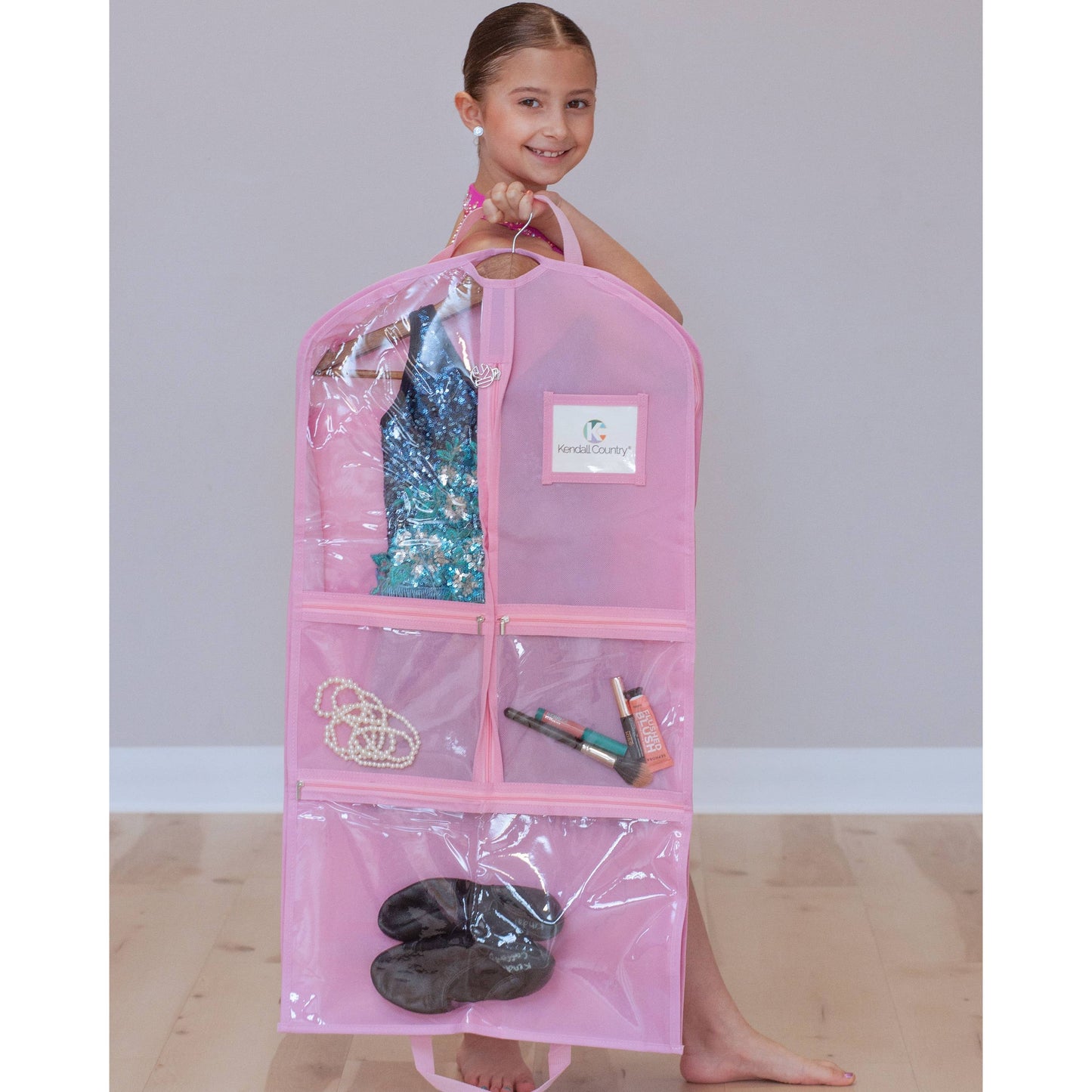 Dancer holding cotton candy (pink) coloured garment bag with clear pockets