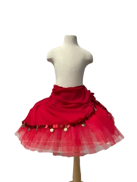 A bright red costume skirt displayed on a cream mannequin torso. The skirt features a gathered red fabric waist section, a layered tulle hem, and hanging gold and red coin embellishments.