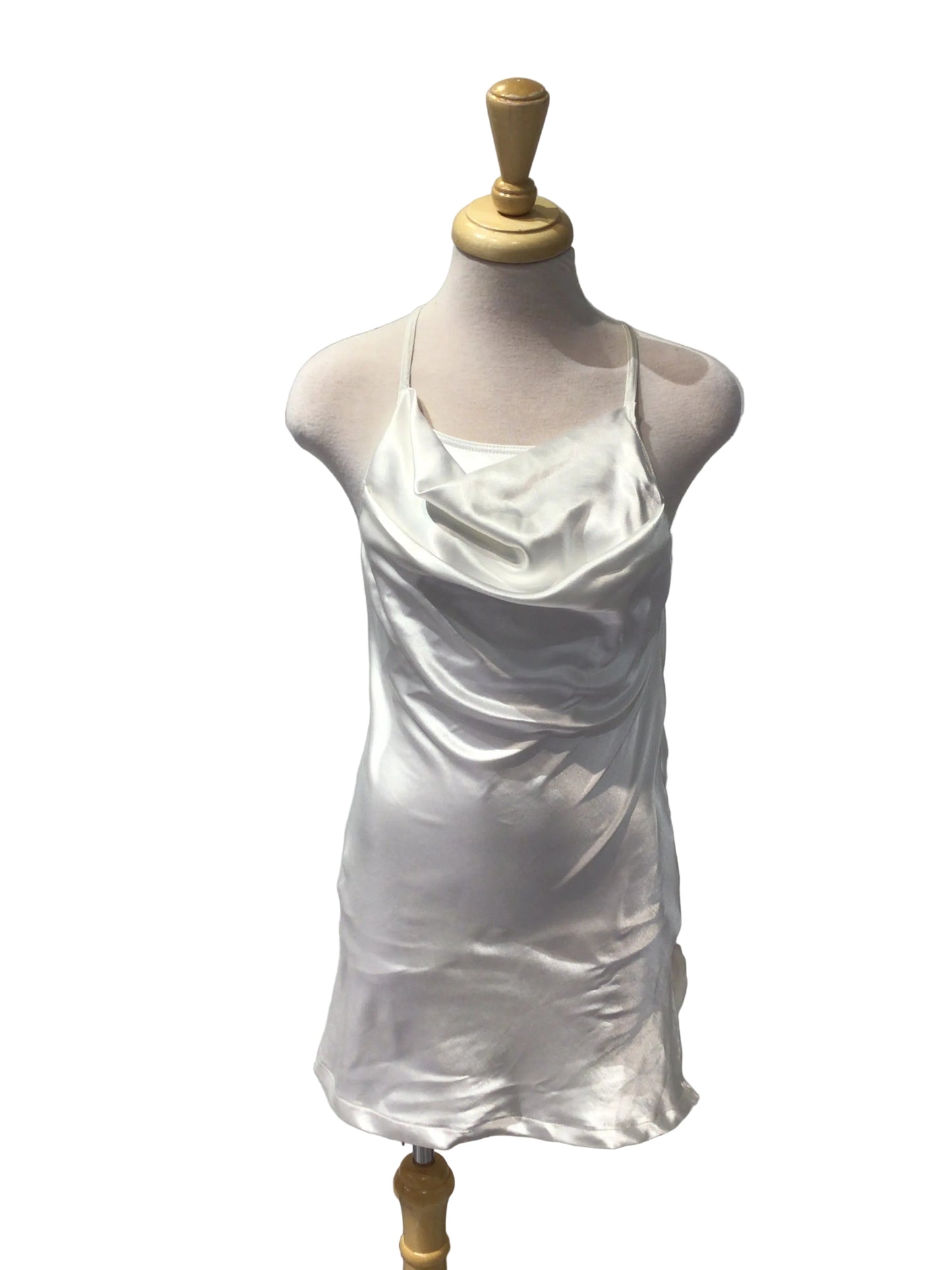 A white satin or silk dress form cover draped over a mannequin torso, mounted on a wooden dress form against a white paneled wall.